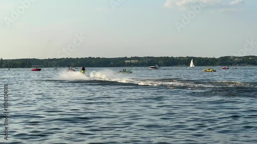 Warsaw, Poland - August 28, 2025: Jet ski rider speeds across shimmering lake, surrounded by boats and sailboats, showcasing thrilling water sports action with dynamic camera movement