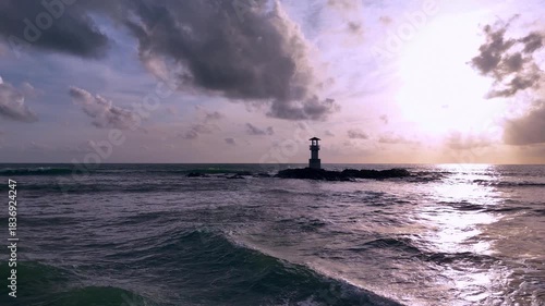 Aerial view of tranquil seaside lighthouse at sunset shoreline 