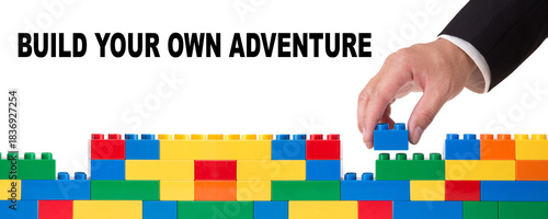 Hand building colorful toy bricks wall with message