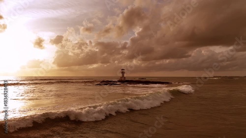 Aerial view of tranquil seaside lighthouse at sunset shoreline 