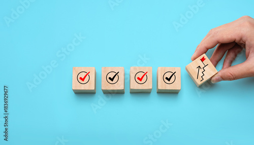 Success building concept with hand stacking wooden blocks step by step, showing checkmarks and progress icons, representing achievement, planning, strategy, and long-term development.