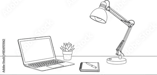 Home office workspace with laptop and lamp