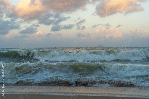 Beautiful sunset over the ocean with dramatic clouds and  wave.