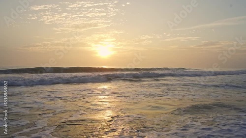 Beautiful sunset over the ocean with dramatic clouds and  wave.