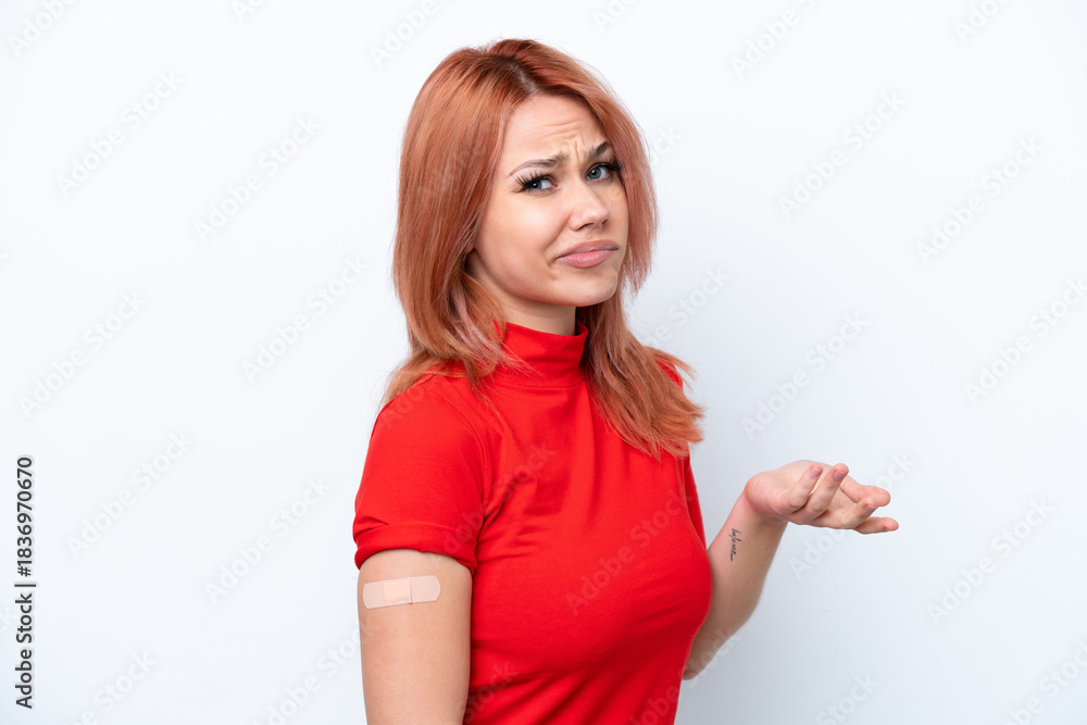 Fototapeta premium Young Russian girl wearing band-aids isolated on pink background making doubts gesture while lifting the shoulders