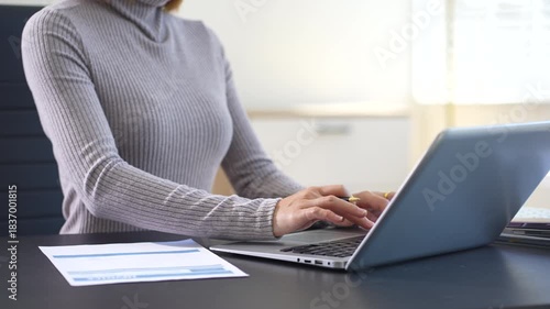 Business woman working on laptop and accounting financial report, accountant using calculator to calculate tax refund at office