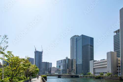 川沿いの緑と高層ビル群が並ぶ日本の都市風景