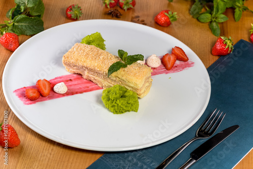 dessert napoleon cake on a plate with fresh strawberries