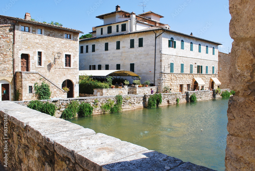 Fototapeta premium L'antica vasca termale, nota come Piazza delle Sorgenti, nel cuore di Bagno Vignoni in Val d'Orcia in provincia di Siena, Toscana, Italia.
