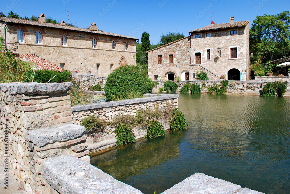 Fototapeta premium L'antica vasca termale, nota come Piazza delle Sorgenti, nel cuore di Bagno Vignoni in Val d'Orcia in provincia di Siena, Toscana, Italia.