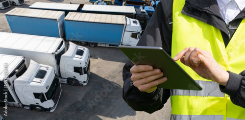 Aerial view of a large truck parking lot at a logistics hub, with multiple commercial semi trucks parked in organized rows