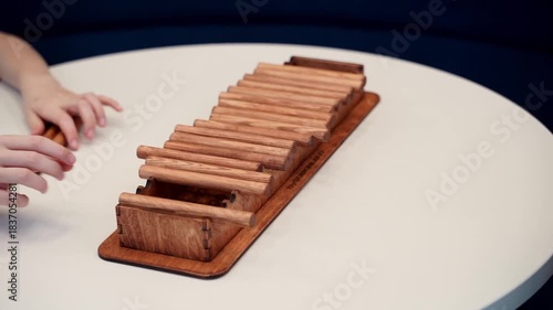 Hands interact in a board game with wooden sticks on the table, demonstrating the ability to analyze and think.