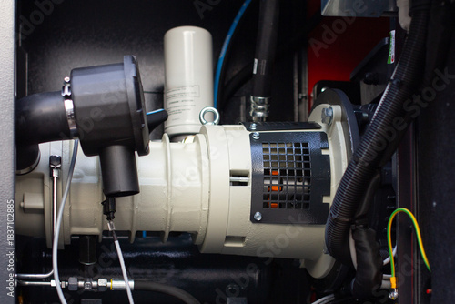 Foto A modern industrial electric motor or generator component with oil filter, hoses