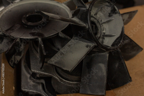 Fotografie Macro shot of broken, disassembled black plastic fan blades and impeller compone