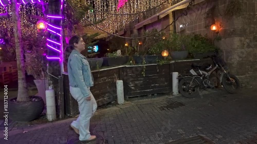 Woman Posing with Festive Neon Lights in a City at Night. Akko Old City, Israel.