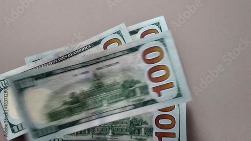 Close-up of hundred dollar bills falling on the table