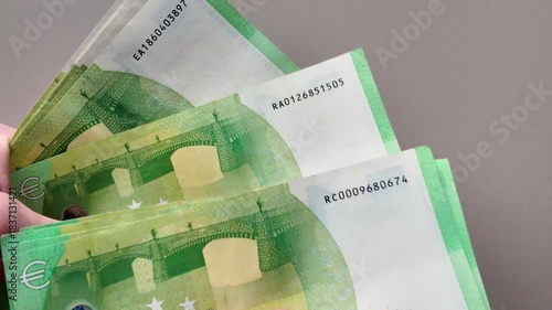 Close-up of a man's hands counting a wad of 100-euro banknotes