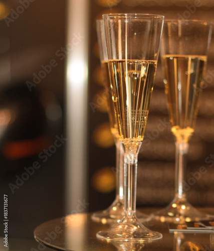 Sparkling wine stock photo. Champagne flutes on dining table. Toast or holiday celebration. 