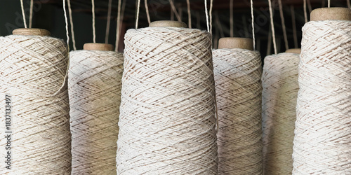 Naturl colored yarn spools in fabric production in textile factories.