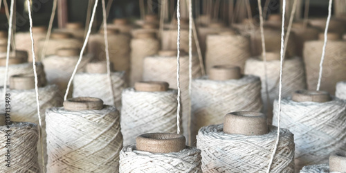 Naturl colored yarn spools in fabric production in textile factories.