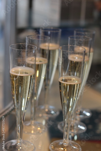 Sparkling wine stock photo. Champagne flutes on dining table. Toast or holiday celebration. 