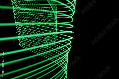 Long exposure light painting photography. Swirls of green light in parallel lines against a black background