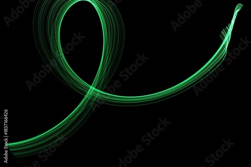 Long exposure light painting photography. Swirls of green light in parallel lines against a black background