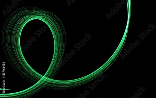 Long exposure light painting photography. Swirls of green light in parallel lines against a black background
