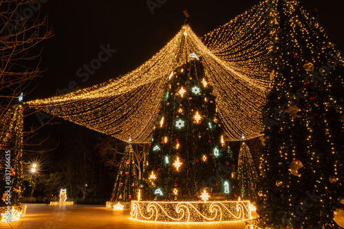 Wallpaper Mural Illuminated Christmas trees in a festive night city square, creating a magical holiday scene. Torontodigital.ca