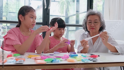 Joyful Generations: A heartwarming scene unfolds as a grandmother and two granddaughters engage in a craft activity, showcasing the beauty of intergenerational connection and creative play.