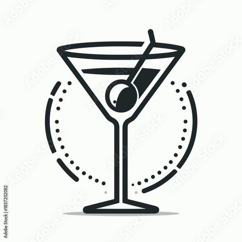 Martini glass with olive and cocktail stirrer on a light background
