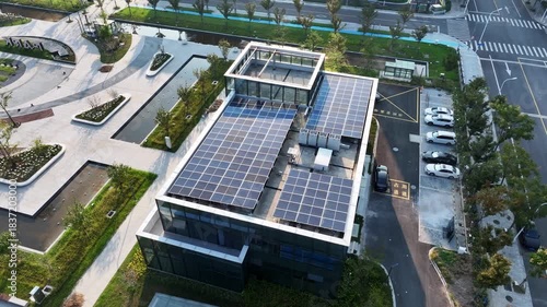 Aerial view of a modern building with solar panels installed on its rooftop in an urban environment