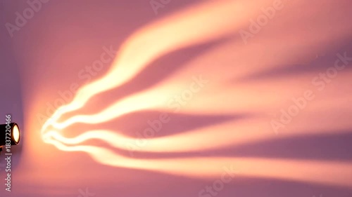 Flashlight Beam Illuminating a Dark Space with Warm Light Trails.