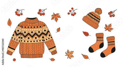 A cozy autumn clothing and accessories set featuring a patterned sweater, a knit hat with a pom-pom, warm socks, maple leaves, and rowan berries for fall season.