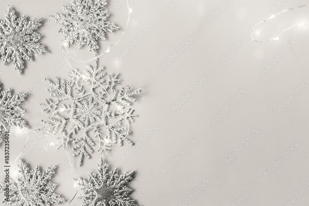 Obraz premium Christmas decor snowflakes with garland white background. Cloud Dancer color trend.