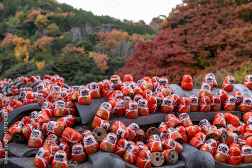 Wallpaper Mural Colorful daruma dolls on a stone altar in a forested area during autumn Torontodigital.ca