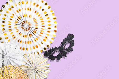 Masquerade Party Decor With Gold Paper Fans, Lace Mask And Mardi Gras Vibes on Pastel Purple Background. Concept Of Festive Styling, Carnival Season, And Elegant Events