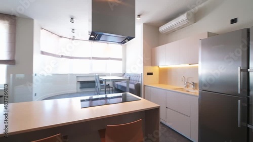 Modern kitchen with gray cabinets, wooden island, stainless steel appliances, and stylish lighting, creating a clean and functional interior design.