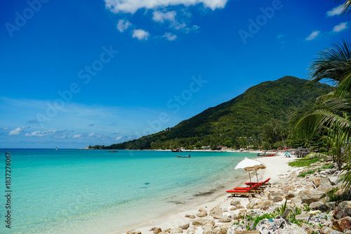Tropical vacation destination. Mountains, turquoise sea and luxury resorts on the coast of the island. Small palm tree and beautiful calm lagoon on Malibu Beach, Koh Phangan, Thailand.