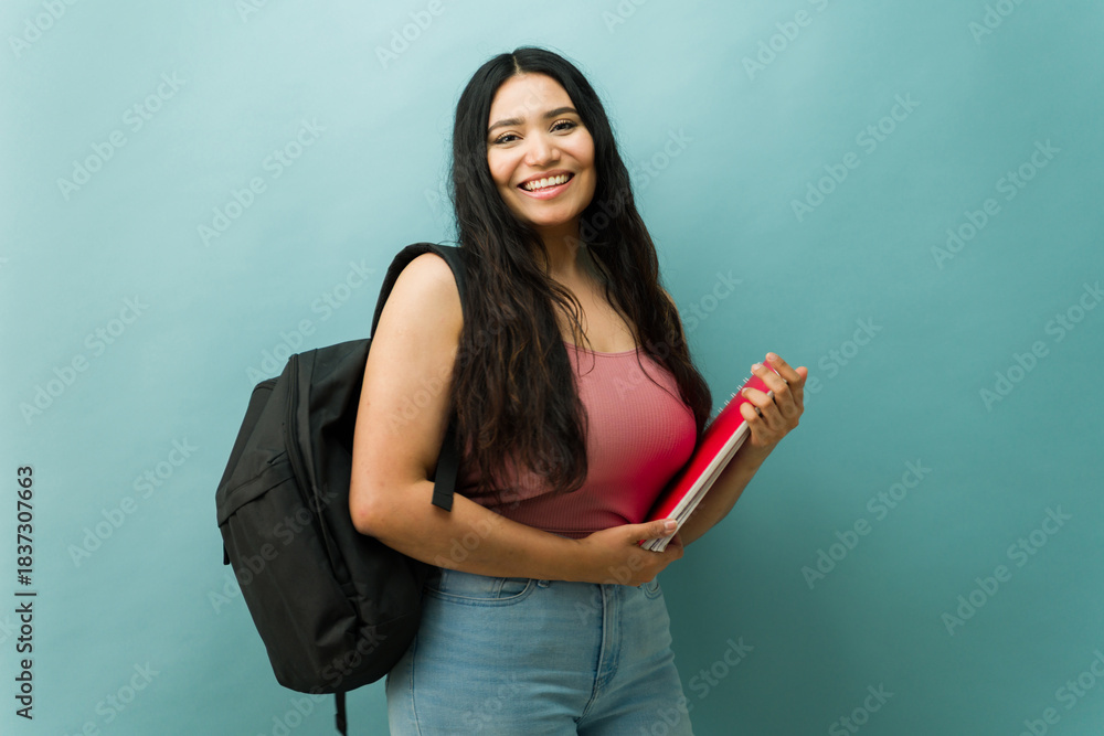 Obraz premium Latin young woman student posing with backpack and notebooks