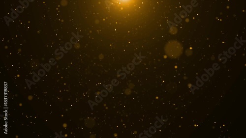 Abstract golden glitter particles falling down from bright light in black space