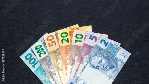 Brazil  money. All Brazilian currency banknotes, reais, arranged in a fan on a black background. Financial business concept. Flat lay. Close up, Copy space