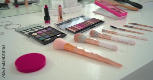 Camera panning right and forward is revealing makeup brushes and palettes to showcase vanity layout