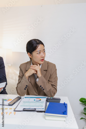 A group of business professionals engaged in a serious office discussion, analyzing financial reports and exchanging ideas to solve problems and make effective corporate decisions.