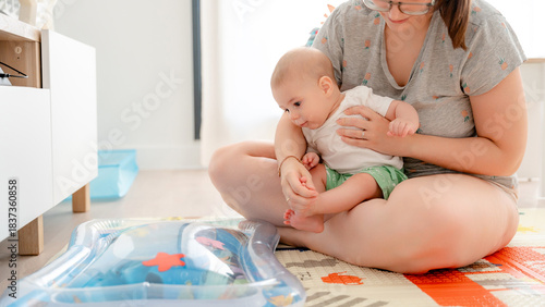 Mother and baby enjoying playtime on colorful mat