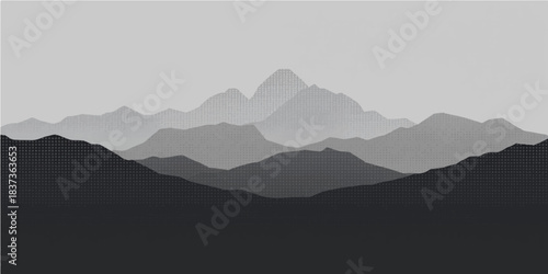 Misty mountain landscape featuring fog covered peaks and green hills under a soft sunrise sky with clouds at morning sunset