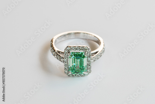 A green and white ring with a diamond in the center