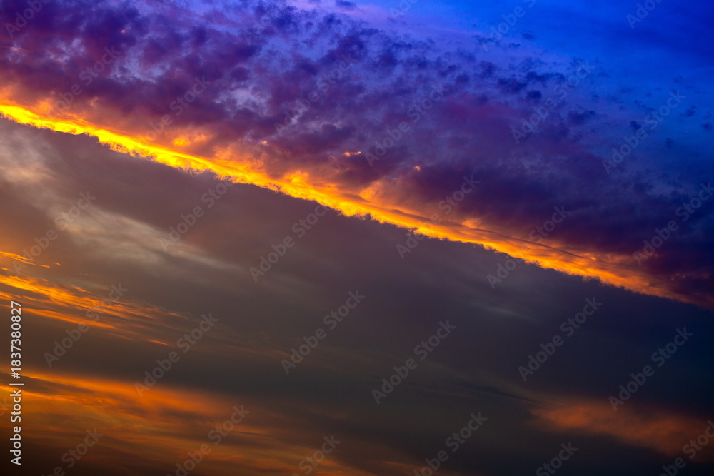 Fototapeta premium Dramatic colorful sunset sky with dark clouds and bright light
