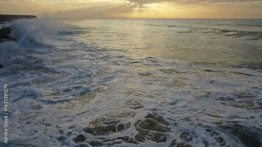 Naklejka premium I watch the waves and contemplate the sunset by the sea