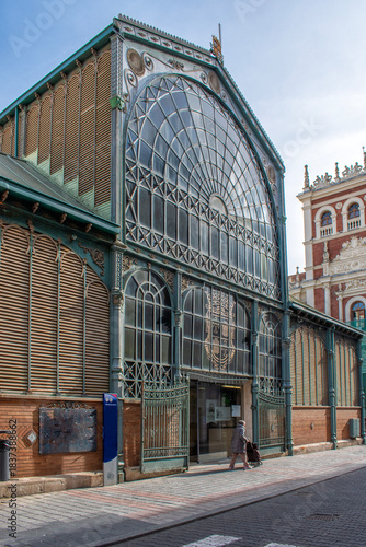 19th-century iron architecture building at one of the entrances to the market hall in the city of Palencia, Spain. The sign next to the entrance has the word written in Spanish, 